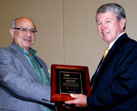 George Milad receives the President’s Award from IPC CEO Denny McGuirk.